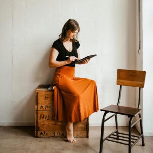 Frau beim Arbeiten mit Tablet in modernem Arbeitsumfeld.